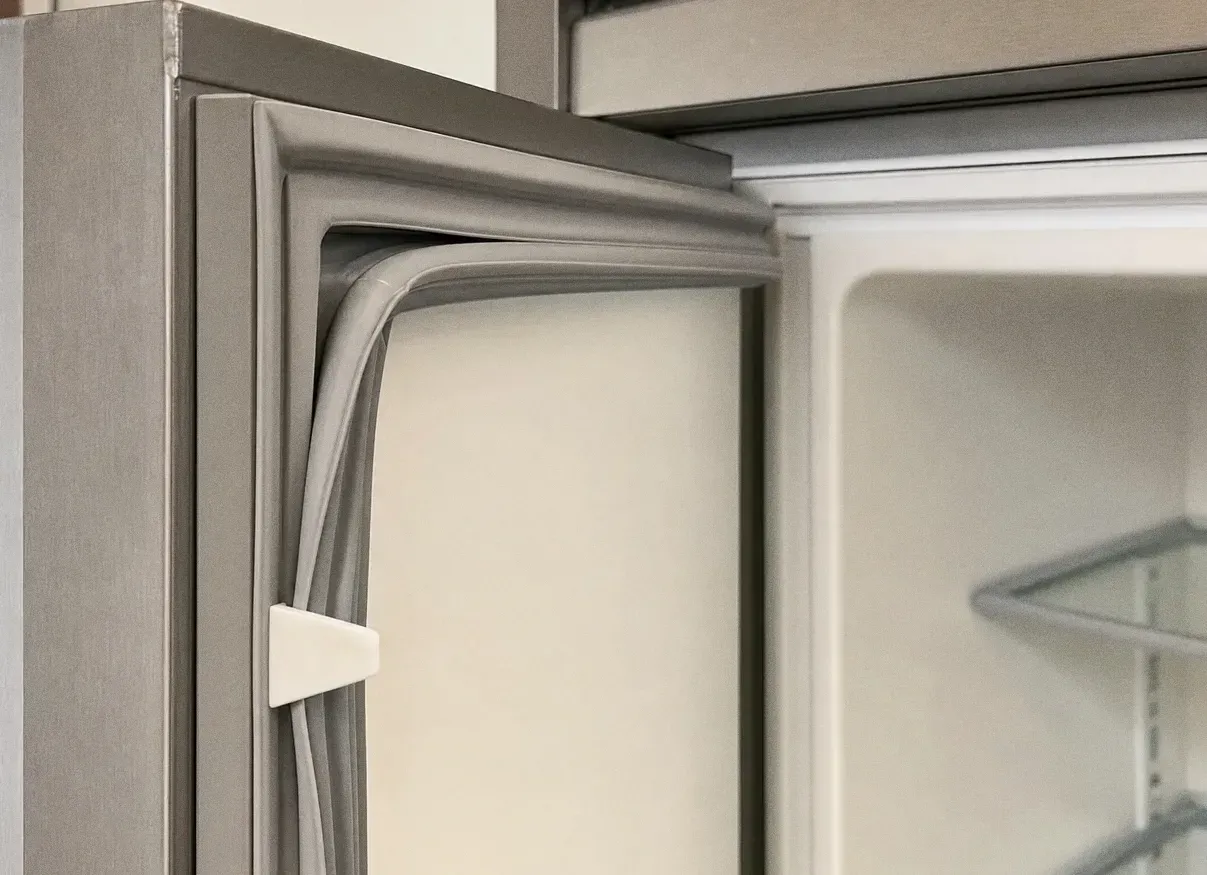 Open appliance door in close view, showing the moulded door gasket against the white cabinet liner